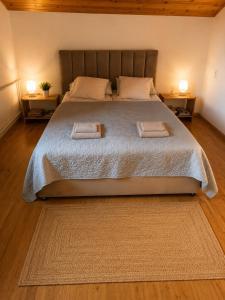 a bedroom with a large bed with two night stands at Saulės Namai in Palanga