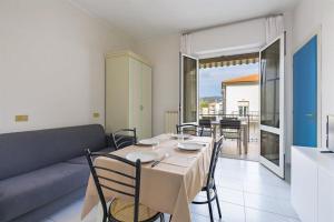 a dining room with a table and a couch at Hotel Residence Mediterraneo in Diano Marina