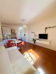 a living room with a white couch and a table at DaMa s Apartment on the beach in Giardini Naxos