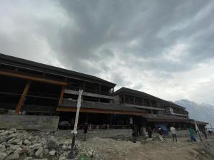 a building on top of a mountain with people standing outside at Kedarnath Aastha Path ME5 Building in Kedārnāth