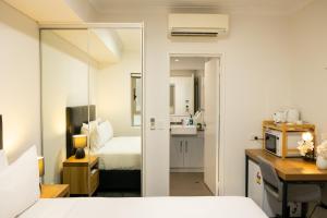 a hotel room with a bed and a bathroom at Baileys Serviced Apartments in Perth