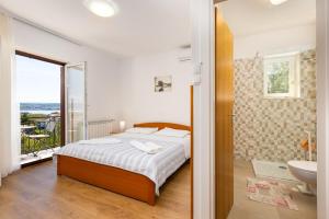 a bedroom with a bed and a bathroom with a sink at Rooms Vera in Porat