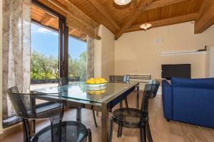 a dining room with a glass table and chairs at Casetta delle Rose sull'etna in Viagrande