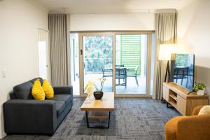 a living room with a couch and a table at Baileys Serviced Apartments in Perth