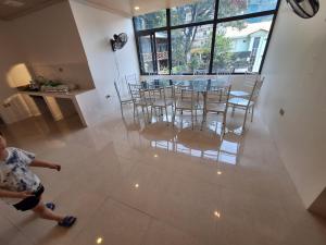 a woman walking through a living room with a table and chairs at Galaxy Villa Tam Đảo in Tam Ðảo +5 photos