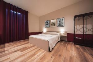 a bedroom with a bed and a wooden floor at Corso52 B&B in Monte Libretti
