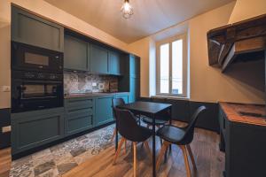a kitchen with blue cabinets and a table and chairs at Corso52 B&B in Monte Libretti