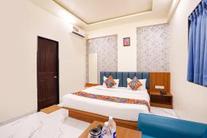 a bedroom with a large white bed with blue curtains at FabHotel Sunrise Comforts in Pune