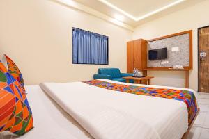 a hotel room with a bed and a tv at FabHotel Sunrise Comforts in Pune