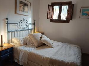 a bed with white sheets and pillows in a bedroom at casita la bugamvilla in Mojácar