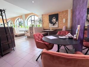a dining room with a table and red chairs at Hotel N Znojmo - Klid, Atmosféra a Zážitek in Znojmo
