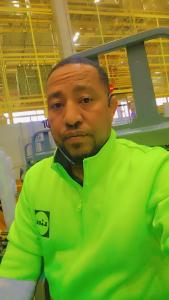 a man in a green shirt standing in a room at Isayas Asfehale Welday in Halmstad