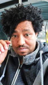a man with black curly hair is posing for a picture at Isayas Asfehale Welday in Halmstad