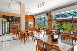 an empty restaurant with wooden tables and chairs at Aby Guest House in Sidemen