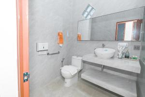a bathroom with a white toilet and a sink at Dewandaru Homestay 1 in Tonogoro +12 photos