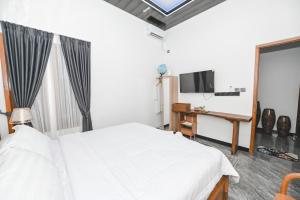 a bedroom with a bed and a flat screen tv at Dewandaru Homestay 1 in Tonogoro