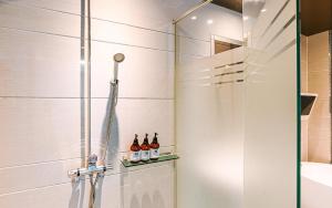 a shower stall with bottles of alcohol on a shelf at Hotel Ssome Jeongkwan in Busan +47 photos