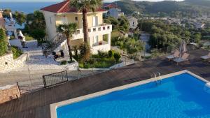 a villa with a swimming pool in front of a house at Diogenis Parga Studios in Parga