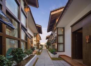 a walkway between two buildings with potted plants at 瓦述loft别院 in Zhangjiajie