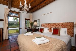 a bedroom with two beds and a chandelier at Oue Werf Country House in Oudtshoorn