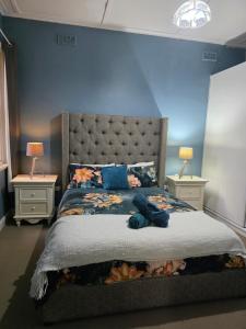 a bedroom with a large bed with two night stands at The Red Manor on Mort in Lithgow