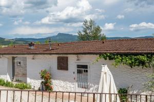a white house with a fence and a umbrella at La Campana d'Oro Bibbiena in Bibbiena