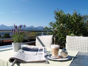 a table with a newspaper and a cup of coffee at Biohotel Eggensberger in Füssen