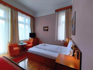 a hotel room with a bed and a chair at Villa Kristal Hotel in Budapest