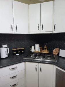 a kitchen with white cabinets and a stove top oven at The Red Manor on Mort in Lithgow