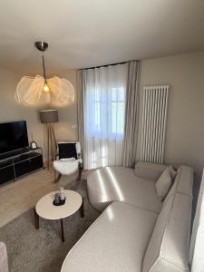 a living room with a couch and a table at Villa El Jardin Bodensee in Lochau