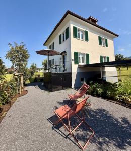a pair of chairs sitting in front of a house at Villa El Jardin Bodensee in Lochau