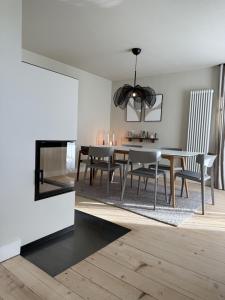 a dining room with a table and chairs and a fireplace at Villa El Jardin Bodensee in Lochau