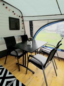 a dining table and chairs in a trailer at Brigga Camping Mietwohnwagen in Ritzingen