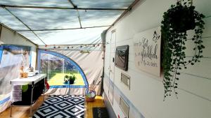 a room with a tent with a table and a window at Brigga Camping Mietwohnwagen in Ritzingen