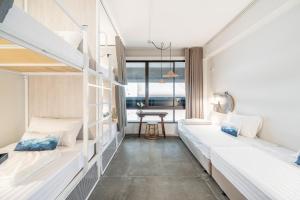 a room with two bunk beds and a table at Unplugged at Bangrak & Silom Design Hostel in Bangkok +150 photos