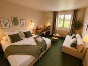a bedroom with a bed and a couch and a window at Hôtel Le Clos des Arts in Gevrey-Chambertin