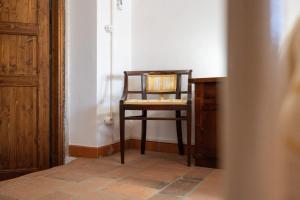 a chair sitting in a corner of a room at La Campana d'Oro Bibbiena in Bibbiena