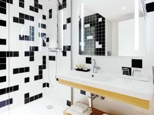 a bathroom with a sink and a mirror at Grand Hotel Bregenz - MGallery Collection in Bregenz +179 photos