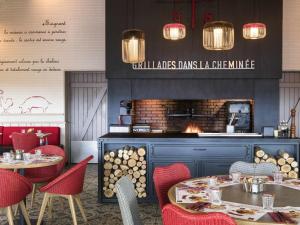 a restaurant with tables and chairs and a fireplace at ibis Reims Tinqueux in Reims +27 photos