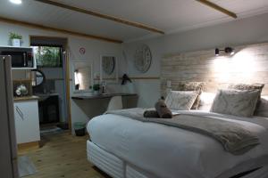 a teddy bear sitting on a bed in a bedroom at Villa Mariss Guesthouse in Kraaifontein
