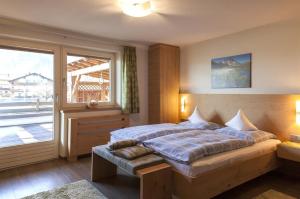 a bedroom with a bed and a large window at Appartements Pfister in Fügen