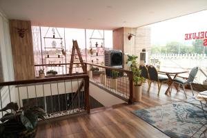 a room with a balcony with a table and chairs at Vilasini Inn in Maddūr