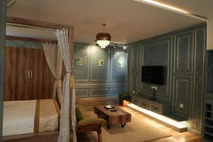 a bedroom with a bed and a table and a tv at Vilasini Inn in Maddūr