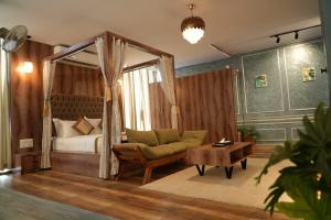 a bedroom with a bed and a couch and a table at Vilasini Inn in Maddūr