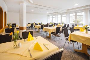 a room with yellow tables and chairs with yellow napkins at Hotel Sonne Rudersberg in Rudersberg