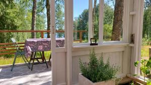 a screened in porch with a table and a chair at Glamping Marsjön & Sauna in Rejböle