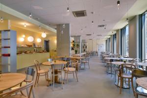 a row of tables and chairs in a restaurant at ibis Leipzig City in Leipzig