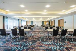 a conference room with tables and chairs and a large rug at Hotel Sonne Rudersberg in Rudersberg