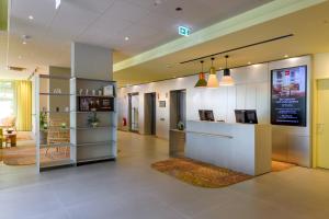 a lobby with a reception desk in a building at ibis Leipzig City in Leipzig