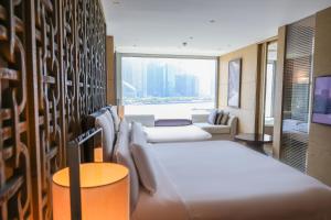 a hotel room with two beds and a large window at Banyan Tree Shanghai On the Bund in Shanghai